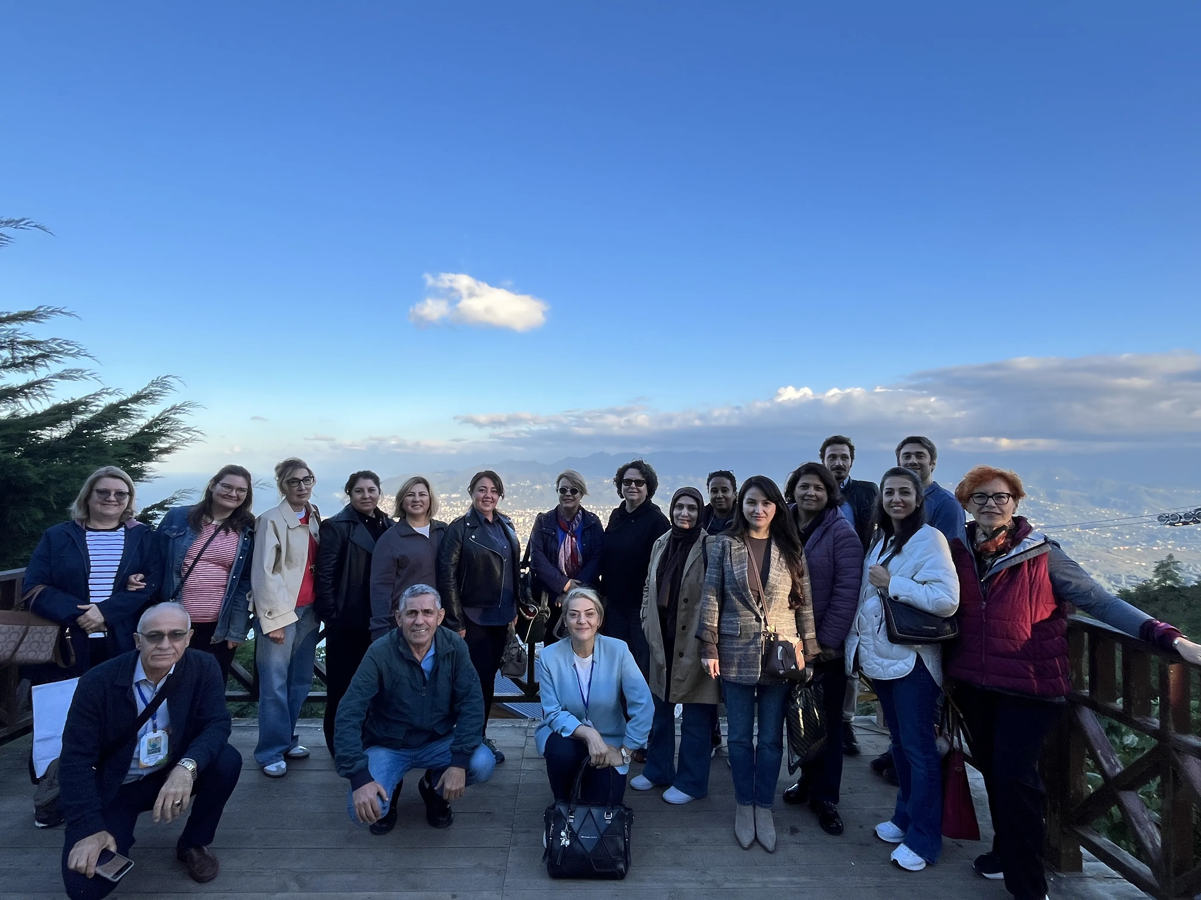 The group on a terrace overlooking a city and mountains